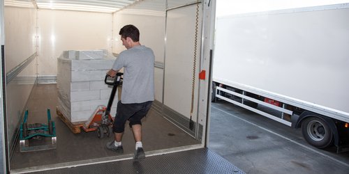 Person using equipment to remove cargo from box truck